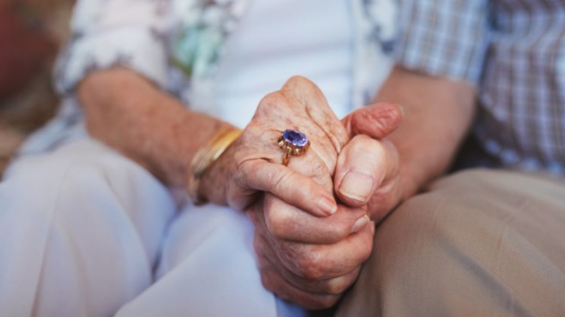 An old couple exchanging sapphire ring or necklace 
