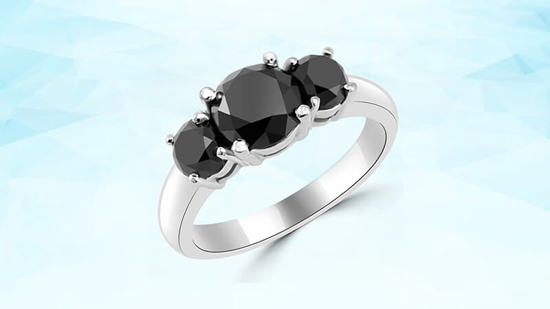 black diamond engagement ring in a three stone setting