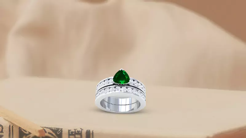 Trillion shaped central emerald with ten prong-set round diamonds