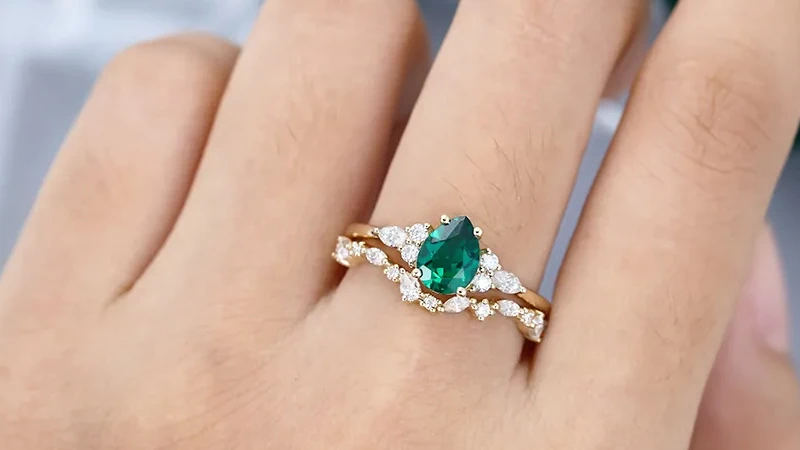 a woman wearing an emerald wedding ring