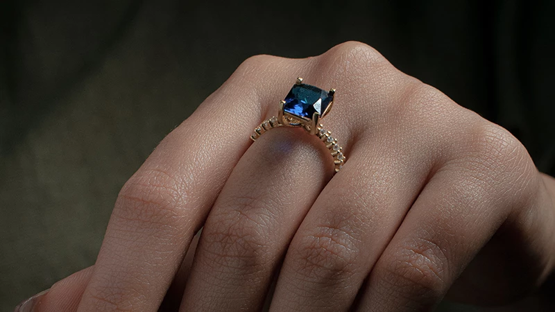 a woman wearing a sapphire wedding ring