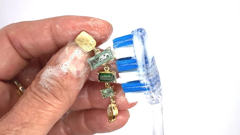 precious gemstones jewelry being cleaned with soap and brush