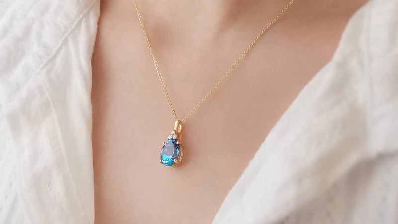 woman wearing blue topaz pendant